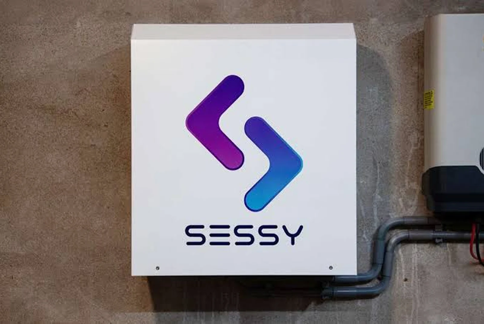 Sessy-thuisbatterij als showmodel, met het Sessy-logo frontaal op de behuizing.